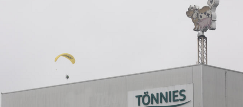 Greenpeace Aktivist landet auf Tönnies Dach mit gelbem Fallschirm 